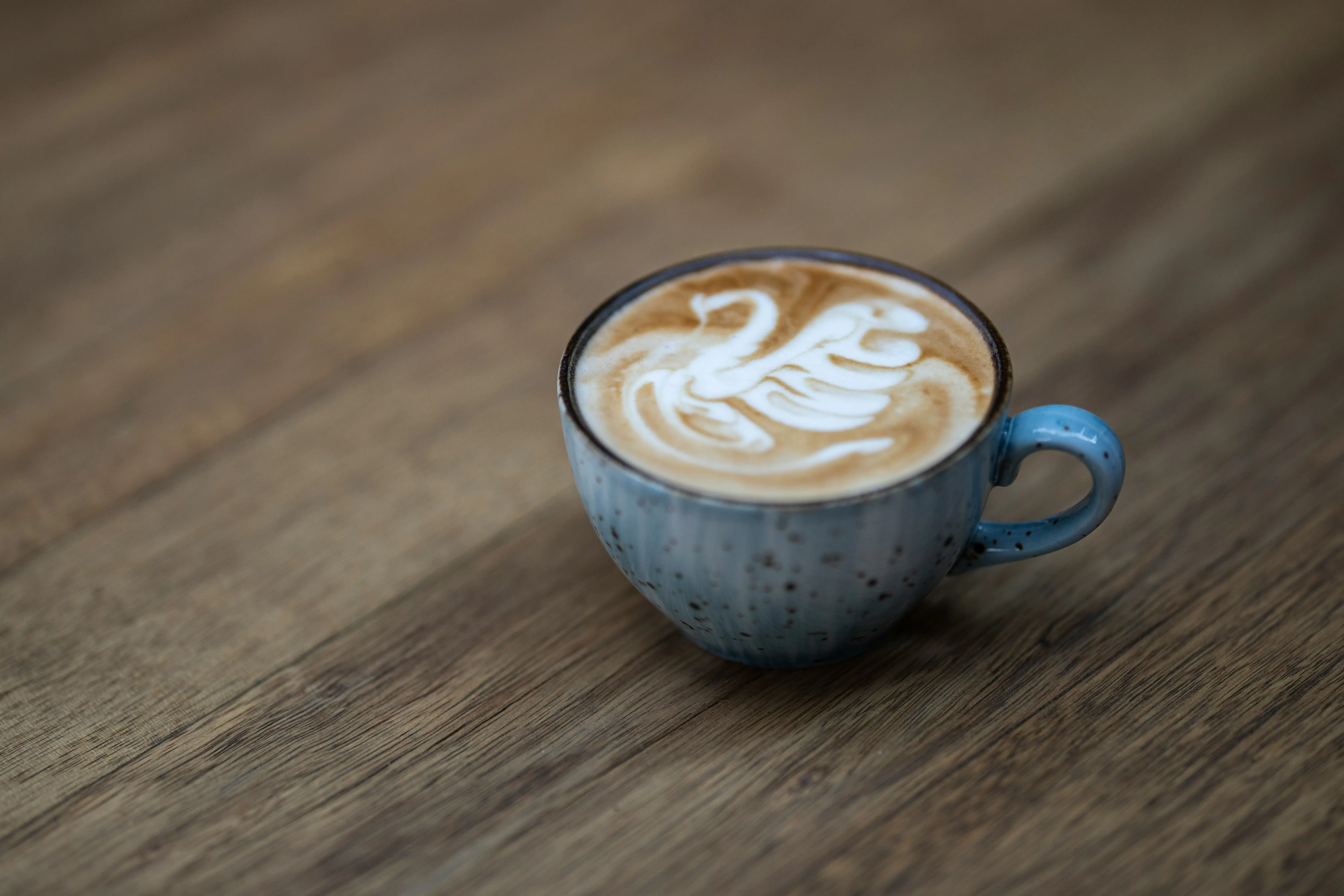 Latte art swan in blue speckled mug
